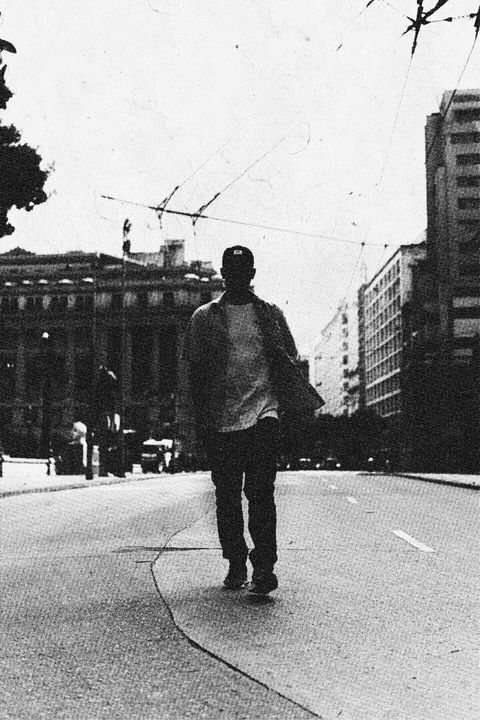 Figura caminhando por uma avenida, preto e branco