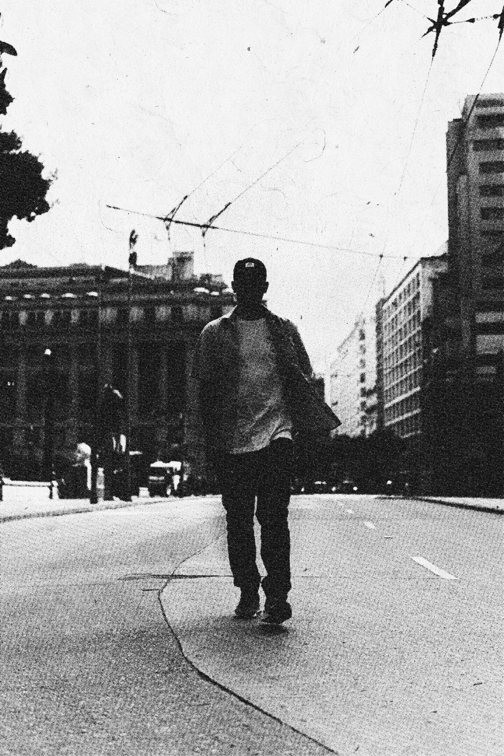 Figura caminhando por uma avenida, preto e branco