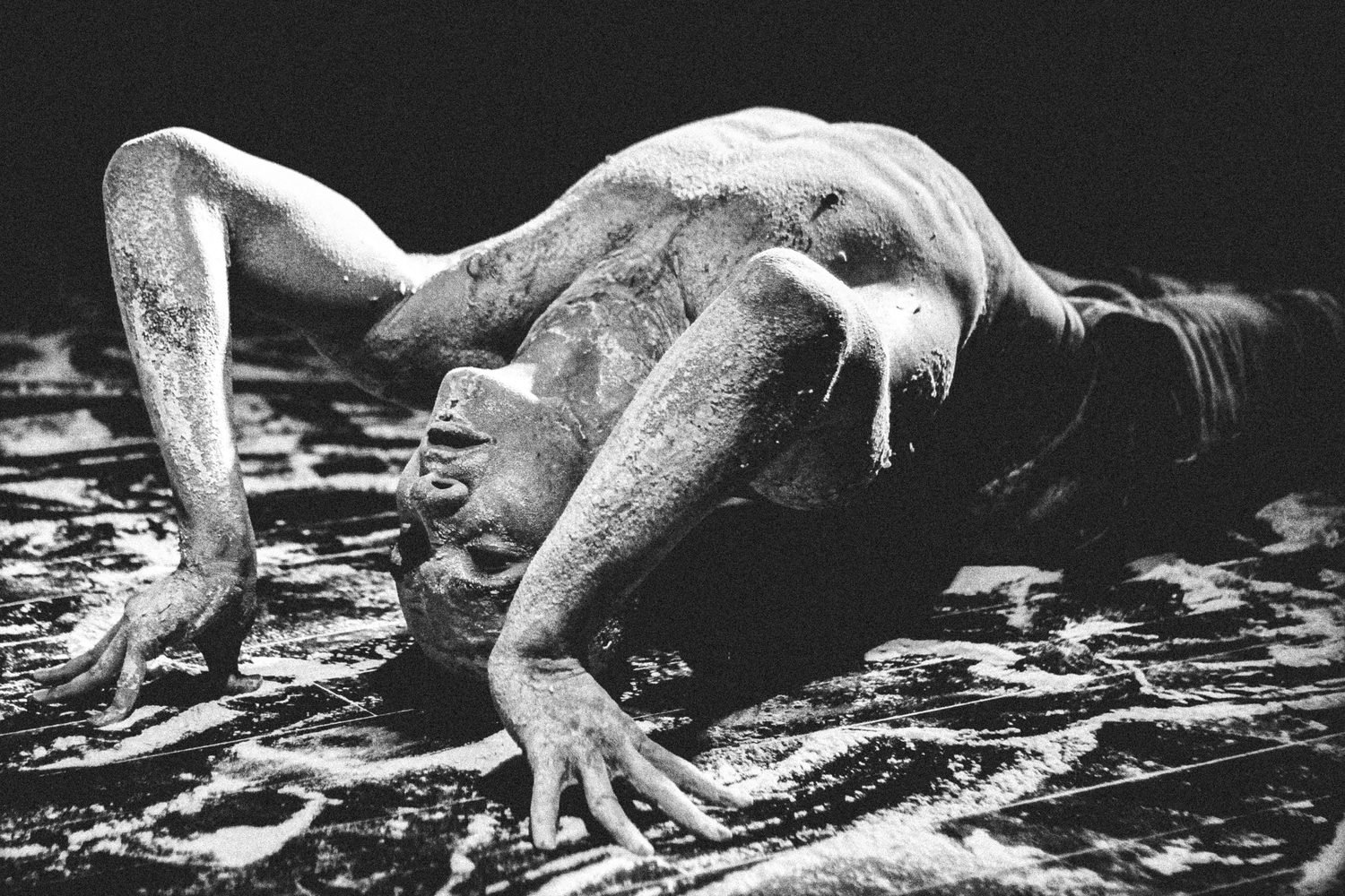 Corpo em performance sobre chão de pó